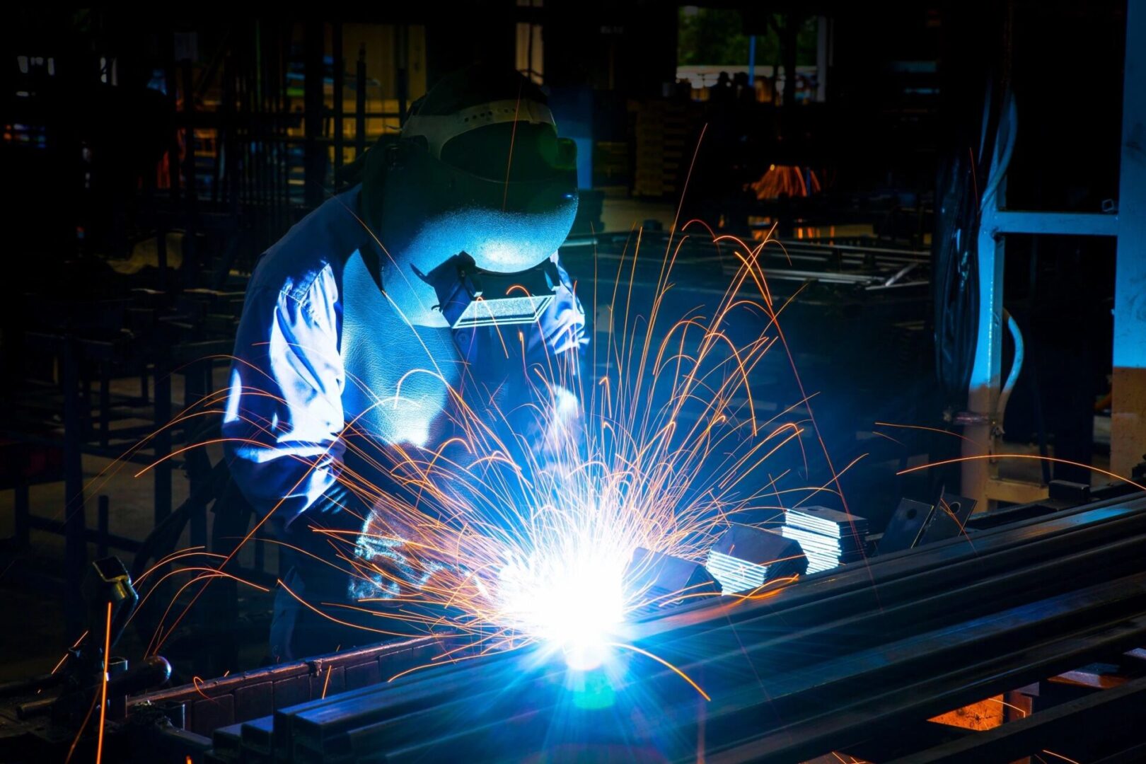 A person welding metal in an industrial setting.