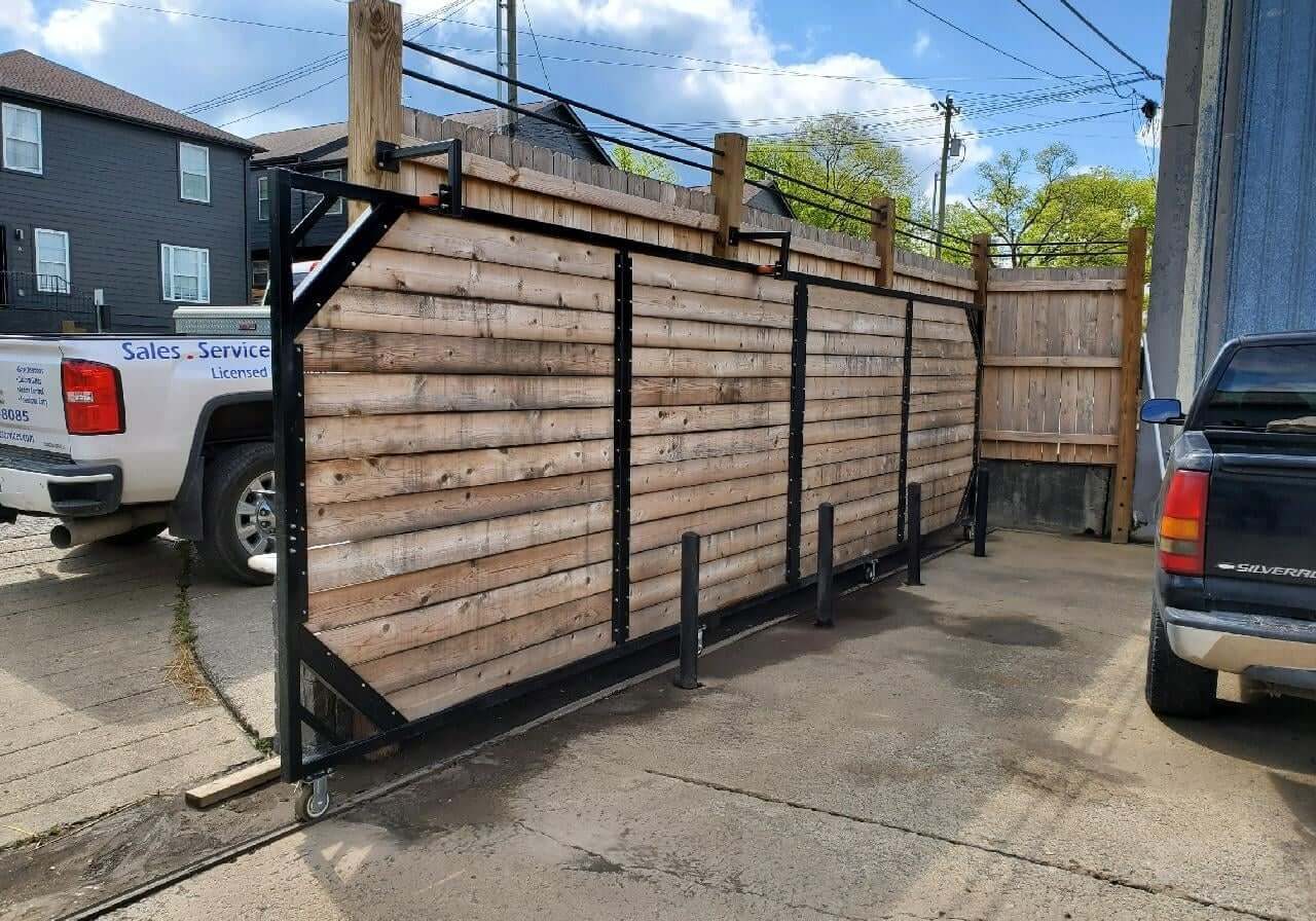 Wooden fence gate in a parking lot.