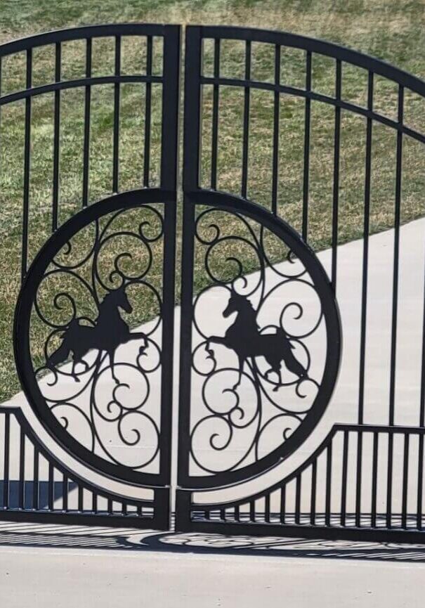 Ornate metal gate with horse design.