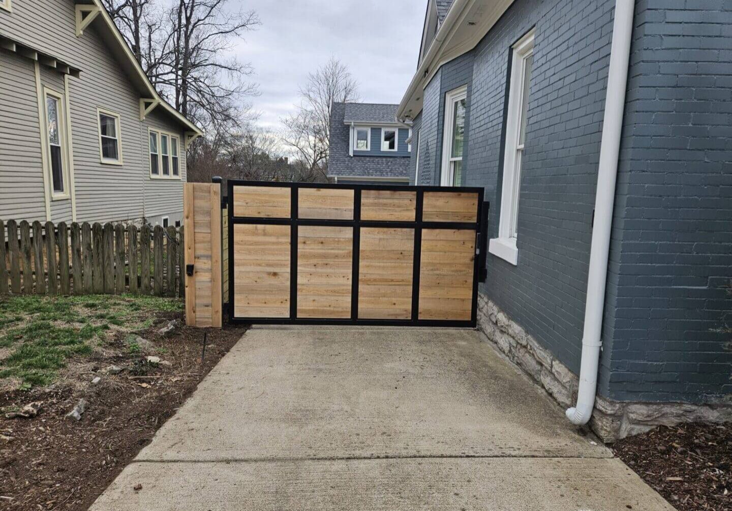 Wooden gate across residential driveway.